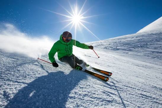 Kar üzerinde carving yapan kayakçı