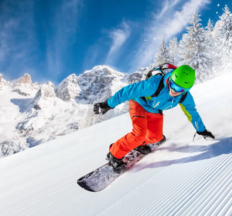 Dağ yamacında snowboarduyla dönüş yapan sporcu.
